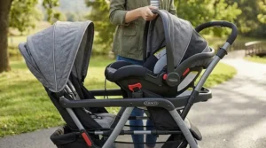Close-up of a Graco SnugRide car seat clicking into the double stroller frame using the travel system technology.