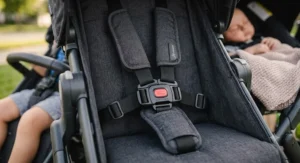 Close-up of five-point safety harness straps on a double stroller seat tailored for infant and toddler security.