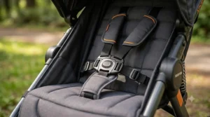 Close-up of a secure five-point safety harness buckled on an infant jogging stroller seat.