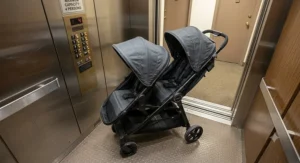 A slim profile double stroller parked comfortably inside a small residential elevator.
