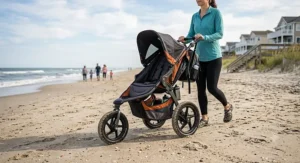 An all-terrain stroller with air filled tires rolling smoothly across a sandy beach path.