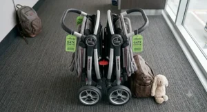 An overhead view of a premium travel double stroller showing one-hand fold mechanisms essential for airplane gate checking.