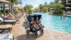 A compact twin stroller for cruise vacations parked on the busy Lido deck near the ship swimming pool.