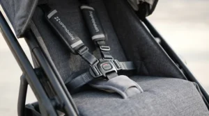 A secure five-point harness inside an infant twin stroller for NICU graduate twins for tiny babies.