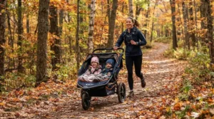 A runner navigating autumn leaves on a trail using a jogging double stroller for marathon training parents