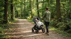 A family enjoying a weekend walk on a nature reserve trail with their single-to-double stroller for growing families.