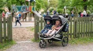 An affordable twin jogging stroller under $450 parked near a suburban playground.